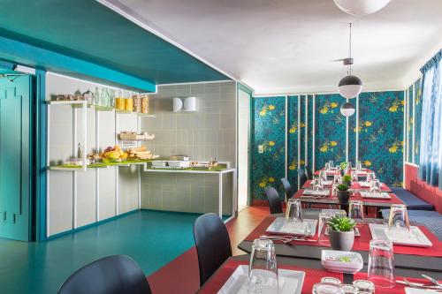 d'une salle à manger avec des tables, des chaises et des murs colorés. dans l'établissement Hôtel les Cigales, à Nice