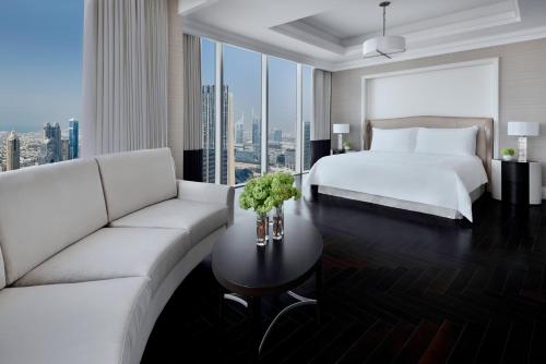 a hotel room with a bed and a couch at Kempinski The Boulevard Dubai in Dubai