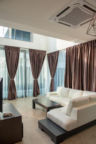 a living room with a white couch and a table at Hermitage Boutique House in Taiping