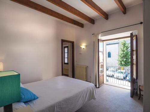 Schlafzimmer mit einem Bett und einer Tür zu einem Balkon in der Unterkunft Casa Galileo in Costitx