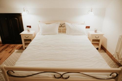 a large white bed in a room with two night stands at La Saca 42 in Saca