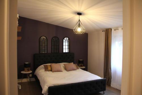 - une chambre avec un grand lit et une tête de lit noire dans l'établissement Gîte Villa Louis Victor, à Villers-sous-Châtillon