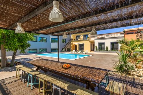 a patio with a table and a swimming pool at Villas Marim in Olhão