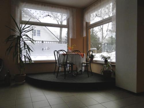 stół i krzesła w pokoju z oknem w obiekcie Pokoje Hotelowe Dux w Łodzi