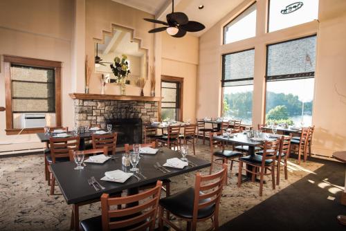 a dining room with tables and chairs and a fireplace at Bayside Resort, Lake George NY in Lake George
