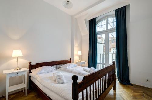 a bedroom with a bed and a large window at Dom & House - Apartment Fiszera Sopot in Sopot