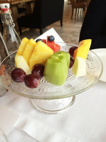 a glass plate with fruits and cheese on a table at Puebloastur Eco Resort Hotel & Spa Gran Lujo in Cofiño