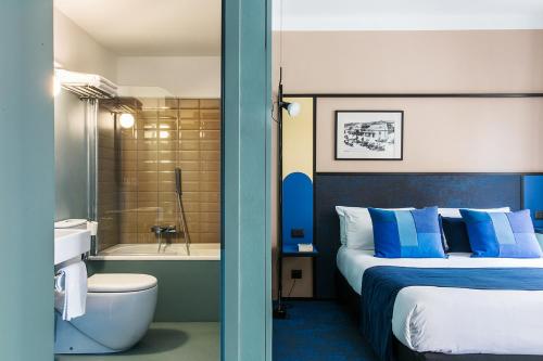 1 dormitorio con 1 cama y baño con bañera en Hôtel les Cigales, en Niza
