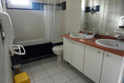 ビスカロッスにある32 RÉSIDENCE LES DEMEURES D'HECTOR -091のバスルーム(洗面台2台、トイレ、バスタブ付)