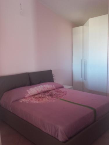 sypialnia z fioletowym łóżkiem i szafką w obiekcie Mare Dune Laghetto w mieście Torre dei Corsari