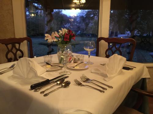 a table with a white table cloth and utensils on it at Inn On The River in Glen Rose