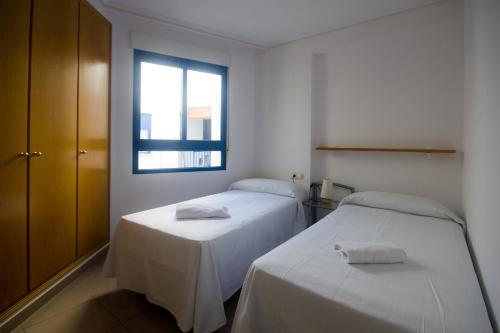 バレンシアにあるStyle Apartment Patacona Beachの白い部屋 ベッド2台 窓付