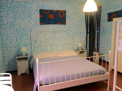 a bedroom with a white bed and blue wallpaper at B&B Ca' da Lina in Deiva Marina