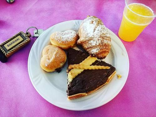 a plate of food with a piece of cake and pastries at Hotel Barbiani in Rimini