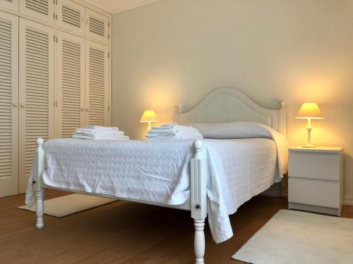 - une chambre avec un lit blanc et 2 lampes dans l'établissement Apartamento Canto da Maia, à Ponta Delgada