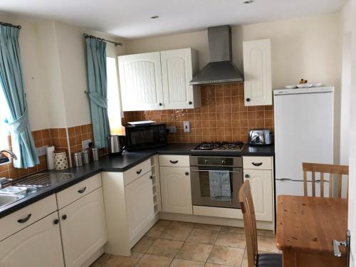 a kitchen with white cabinets and a stove top oven at Jubilee House in Oakham