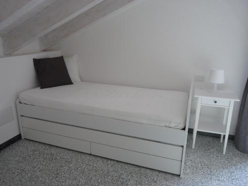 a small bedroom with a white bed and a nightstand at Penthouse by the Sea in Levanto