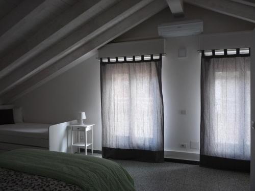 a bedroom with two curtains and a bed and a table at Penthouse by the Sea in Levanto