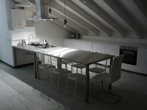 a kitchen with a table with chairs and a sink at Penthouse by the Sea in Levanto