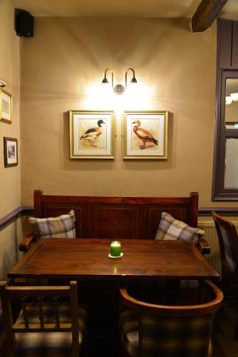 a dining room table with chairs and a bird on the wall at The Devonshire Grassington in Grassington