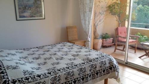 a bedroom with a bed with a black and white blanket at Rochemarine in Théoule-sur-Mer