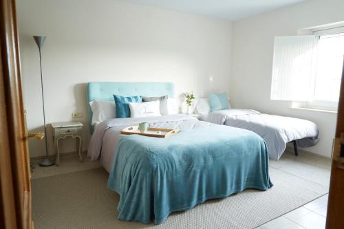 a bedroom with two beds with blue and white at La Mama in El Gurb