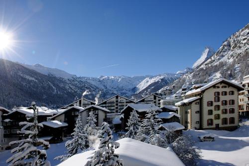 a resort in the mountains covered in snow at Hotel Ambassador Zermatt in Zermatt