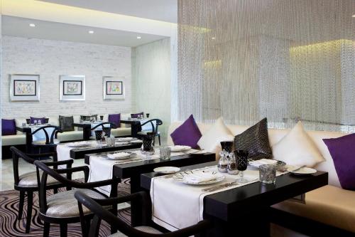 a restaurant with tables and chairs with purple accents at Sofitel Abu Dhabi Corniche in Abu Dhabi