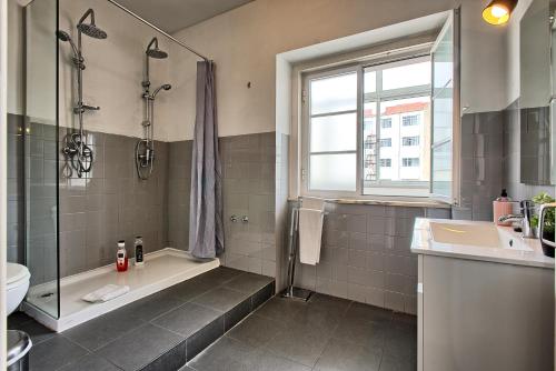 a bathroom with a shower tub and a sink at São Pedro 30 Guests Apartment in Lisbon