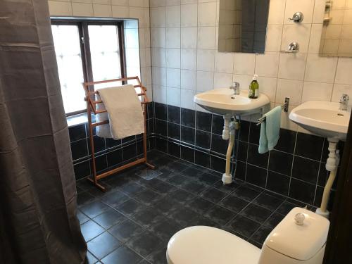 La salle de bains est pourvue de 2 lavabos et de toilettes. dans l'établissement Bed & Breakfast Höllviken, à Höllviken