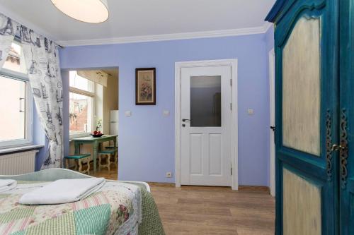 ソポトにあるBay of Sopotの青い壁のベッドルーム1室、ベッド1台、ドアが備わります。