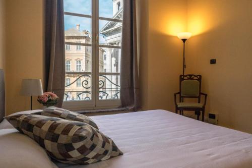 sypialnia z łóżkiem i dużym oknem w obiekcie Nunziata Apartment w Genui