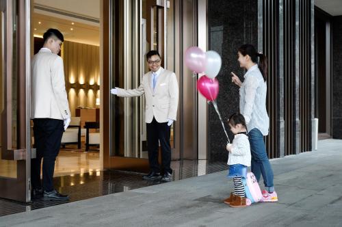 a group of people standing in a lobby with a child holding a balloon at Cuncyue Hot Spring Resort in Luodong