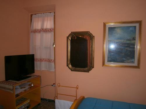 a room with a television and a mirror on the wall at Bed and Breakfast Su Niu in Quartucciu