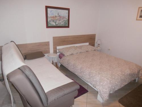 a bedroom with two beds and a table and a picture at Apartment Gabi in Labin