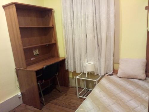 a bedroom with a desk and a window at Guesthouse Monsanto in Porto