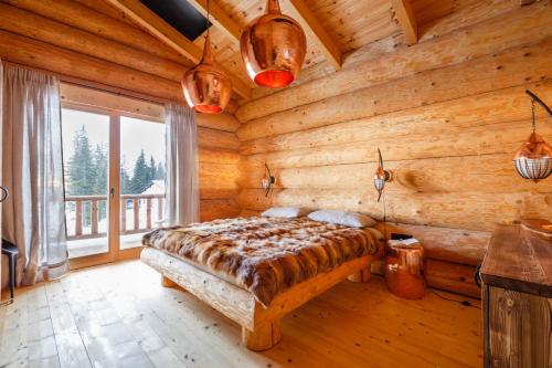 a bedroom with a bed in a log cabin at Klippitz Resort in Klippitztorl