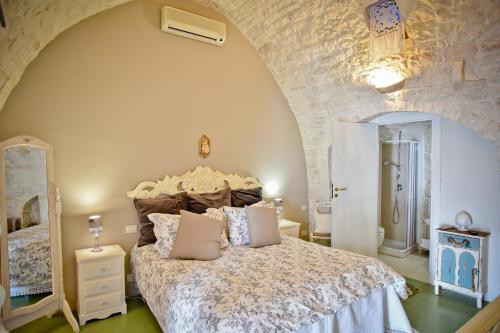 una camera con letto e parete in pietra di La Dimora U Curdunn a Locorotondo