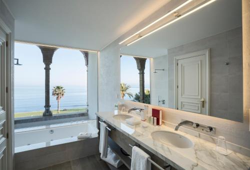 a bathroom with two sinks and a large mirror at Hotel Casa Vilella 4* Sup in Sitges