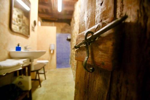 ein Badezimmer mit einer Holztür und einem Waschbecken in der Unterkunft Can Masferrer in Riudarenes