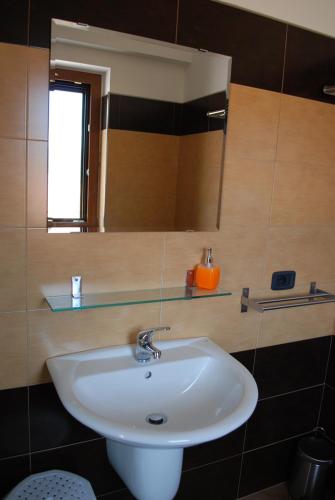 a bathroom with a white sink and a mirror at B & B IL TRATTURO in San Pietro Avellana