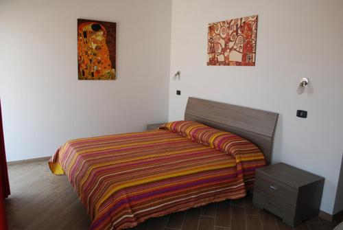 a bedroom with a bed with a colorful blanket on it at B & B IL TRATTURO in San Pietro Avellana