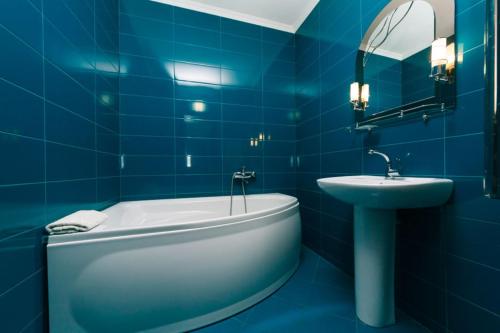 a blue bathroom with a tub and a sink at Харьковское шоссе 19а in Kyiv