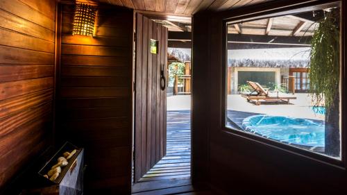 a room with a door and a view of a pool at Sombra e Água Fresca Floresta in Pipa