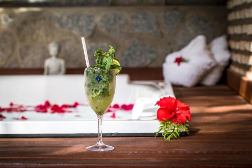 a drink sitting on a table next to a bed at Sombra e Água Fresca Floresta in Pipa