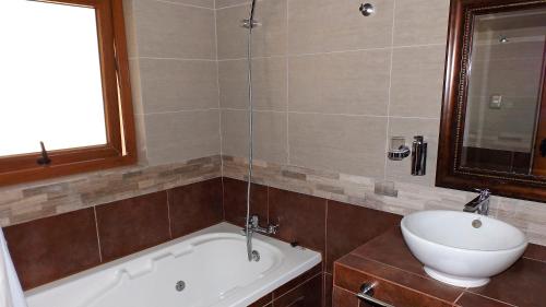 a bathroom with a bath tub and a sink at La Perla Hotel in Santa Cruz