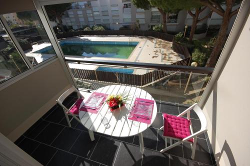 d'un balcon avec une table et des chaises, ainsi que d'une piscine. dans l'établissement Grand studio la Presqu'île 2, à Gruissan