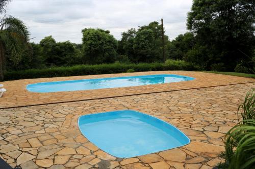 two blue swimming pools on a stone patio at Elsenau Hotel in Tabapira