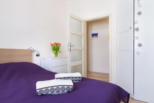a bedroom with a purple bed with two pillows on it at Apartament Kantaka in Poznań