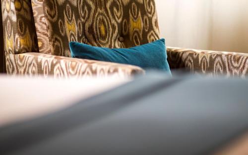 a brown couch with a blue pillow on it at The Paramount Hotel Portland in Portland